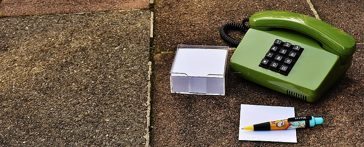 green corded telephone beside black and blue click pen thumbnail