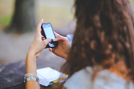 selective focus photo of woman holding smartphone thumbnail