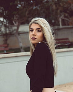 blonde haired woman standing near white wall during daytime thumbnail