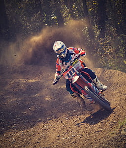 Man in White and Orange Motocross Overall Riding His Motocross Dirt Bike during Daytime thumbnail
