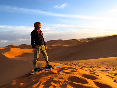 man riding on board white standing on desert at daytime thumbnail