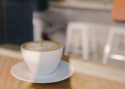 white teacup and saucer filled with coffee thumbnail