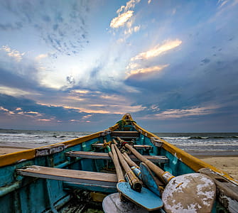 Blue and Beige Boat on Sand Near Ocean thumbnail
