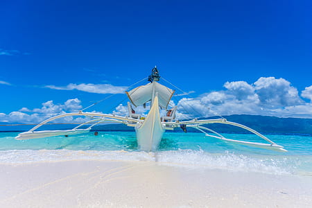 photo of white boat in seashore at daytime thumbnail