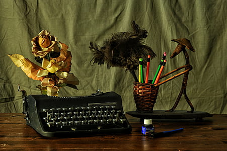 black typewriter beside wicker brown pen holder above table thumbnail
