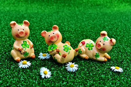 three yellow-and-pink pigs ceramic figurines on green grass thumbnail