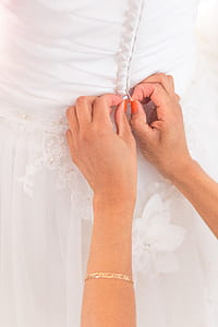 woman inserting button on wedding dress thumbnail