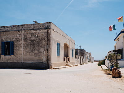 brown concrete building near light post under blue sky thumbnail