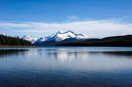landscape photography of snow covered mountain beside body of water under blue sky thumbnail