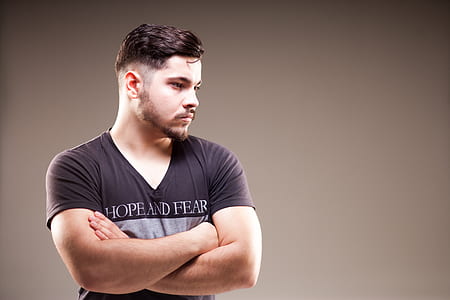 man wearing black shirt against gray wall thumbnail