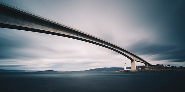 white concrete bridge during gray cloudy sky thumbnail