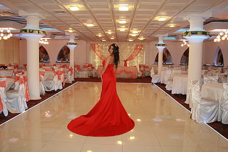 woman wearing red sleeveless dress standing on white tiled floor thumbnail