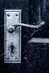 silver door lever on black wooden door thumbnail