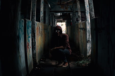 x-eyed man wearing red hoodie sitting between walls with vandalism thumbnail