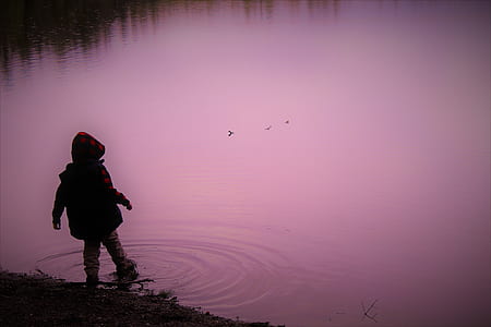 silhouette of child on body of water thumbnail