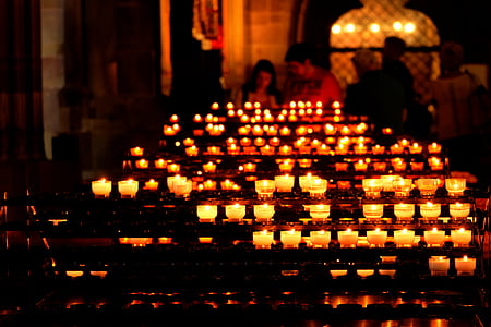 selective focus photography of lighted candles inside church thumbnail