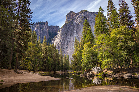 green trees near river and mountain during daytime thumbnail