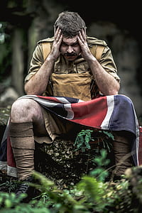 man in brown dungaree shorts with flag thumbnail