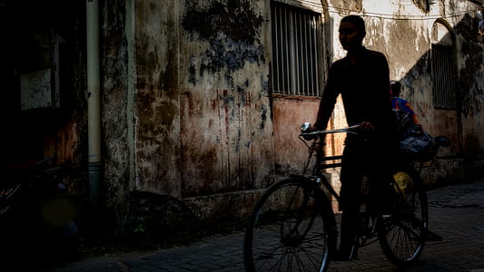 man riding city bicycle on road beside building thumbnail