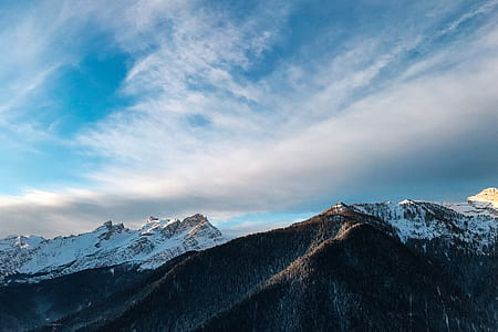 aerial photo of snow-capped mountain under blue sky and white clouds thumbnail