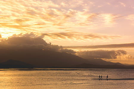 people walking near body of water and island during golden hour thumbnail