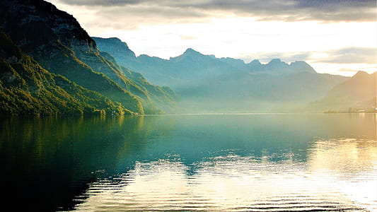photography of body of water near green mountain thumbnail