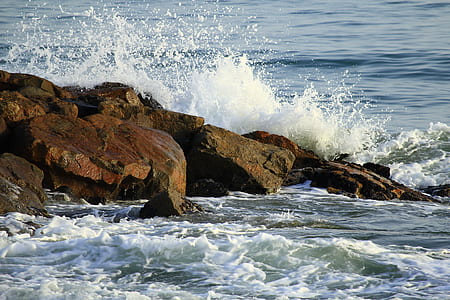 body of water beside brown rocks thumbnail