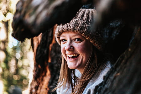selective focus photography of smiling woman wearing gray knit hat thumbnail