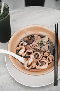 pair of chopsticks on top of brown ceramic bowl thumbnail