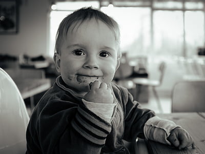 grayscale photo of baby eating thumbnail