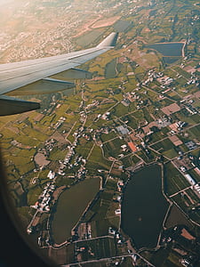 person inside plane taking photo of city thumbnail
