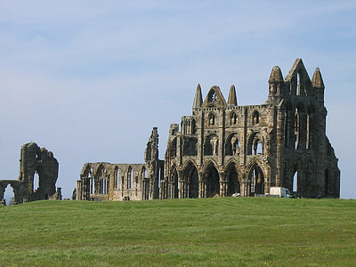 grey concrete ruin mansion on top of green grass field thumbnail