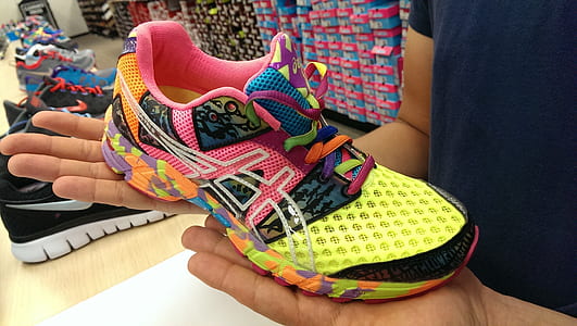 person holding multicolored Asics running shoe thumbnail