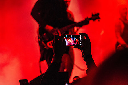 person taking photograph of musical band thumbnail