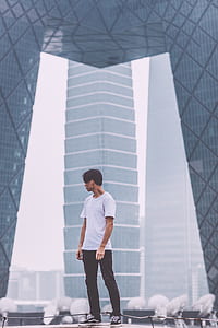 man standing near concrete building during daytime thumbnail