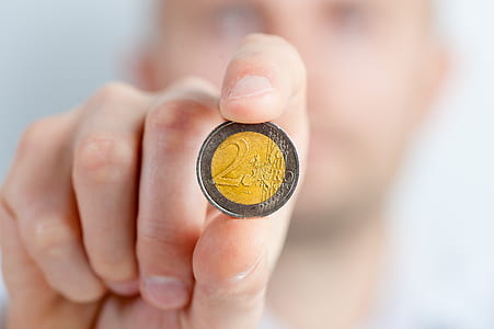 Person Holding a Gold and Silver Round Coin thumbnail