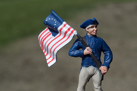 man in blue suit with flag figurine thumbnail