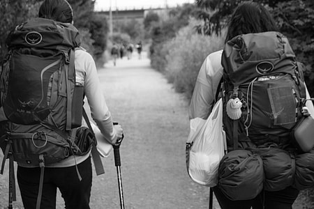 man and woman carrying backpacks thumbnail