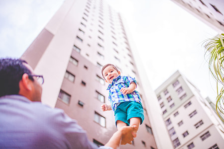 person holding child near building thumbnail