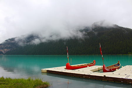 two canoe docked near island covered with clouds at daytime thumbnail