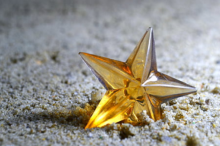 brown glass star ornament on sand thumbnail