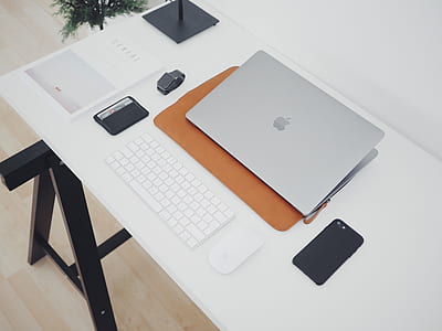 flat lay photo of silver MacBook near black smartphone and wireless Apple Keyboard thumbnail