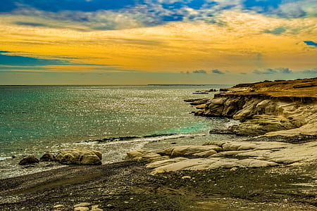 landscape photography of rocks and body of water thumbnail