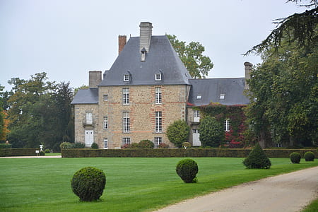 beige concrete house front of green grass field at daytime thumbnail