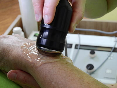 closeup photography of person holding black device on person's arm with clear liquid thumbnail
