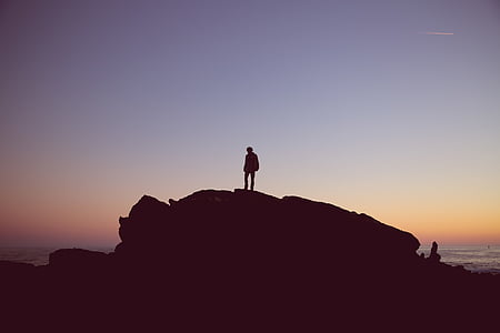 person on rock by the beach thumbnail
