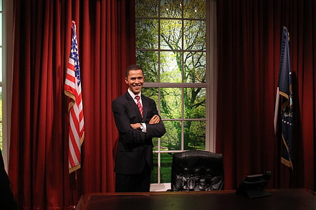 man standing in front of window beside wooden desk thumbnail