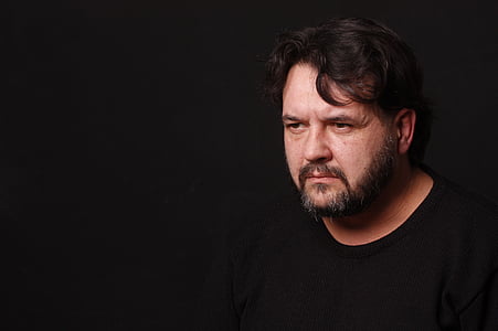 man wearing black crew-neck shirt with dark background thumbnail