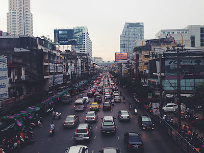 aerial photography of vehicles on road near buildings under white sky at daytime thumbnail
