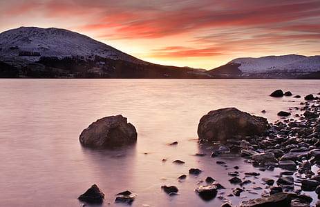landscape photography of mountain beside sea thumbnail